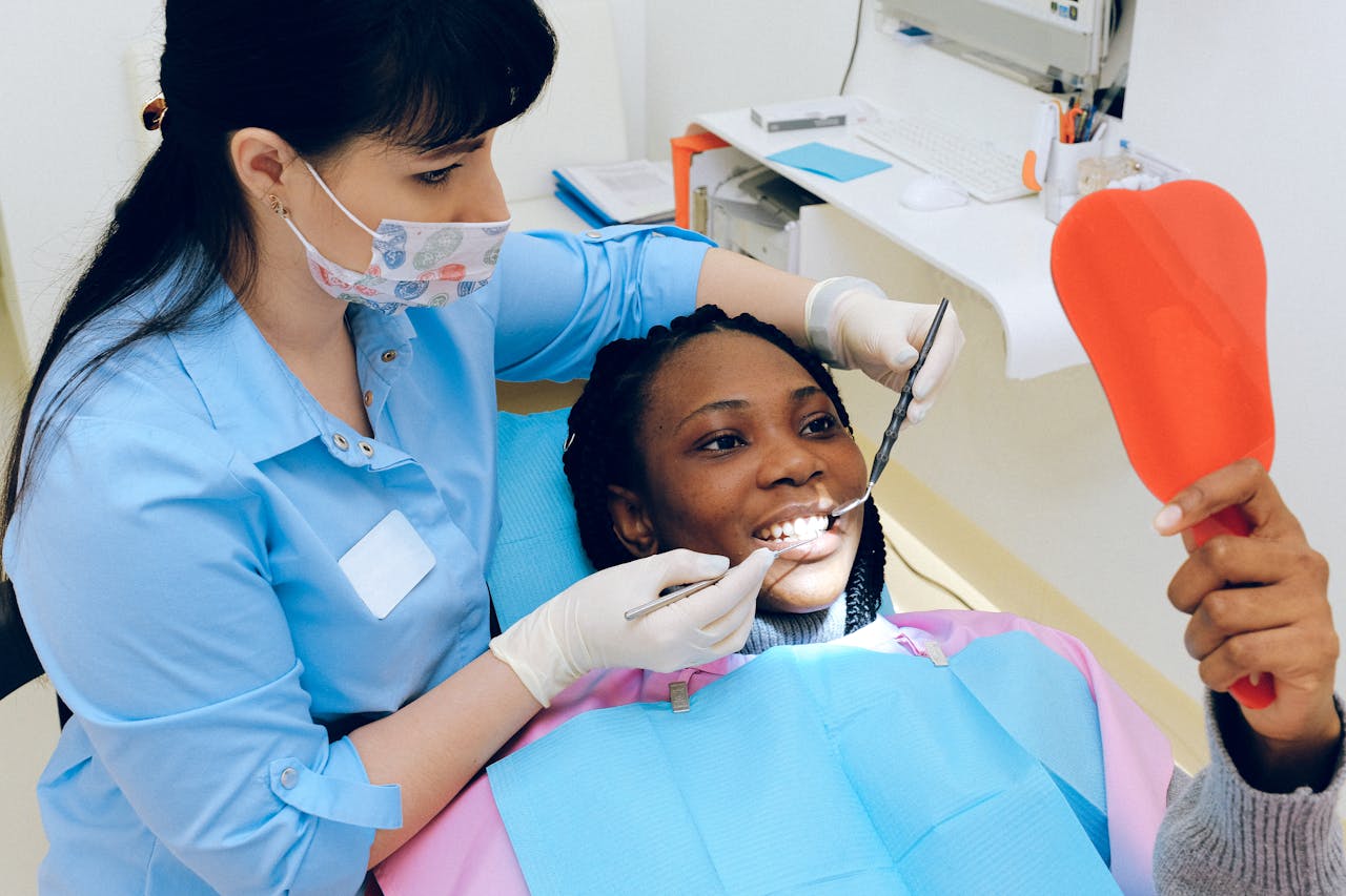 A female dentist checks a patient's teeth during a dental appointment.